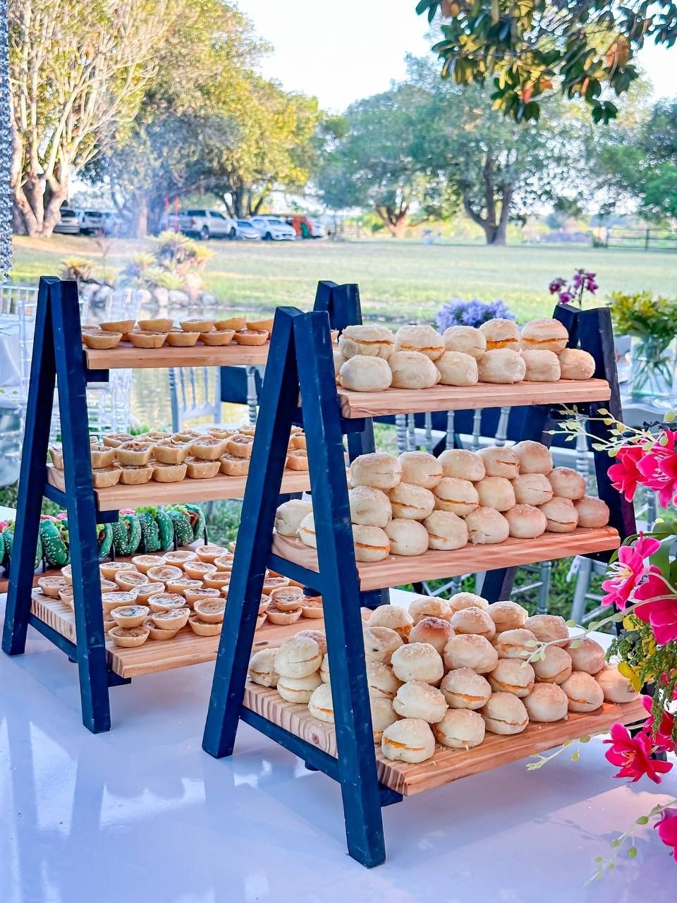 Estandes com pãezinhos recheados e mini-quiches em evento ao ar livre