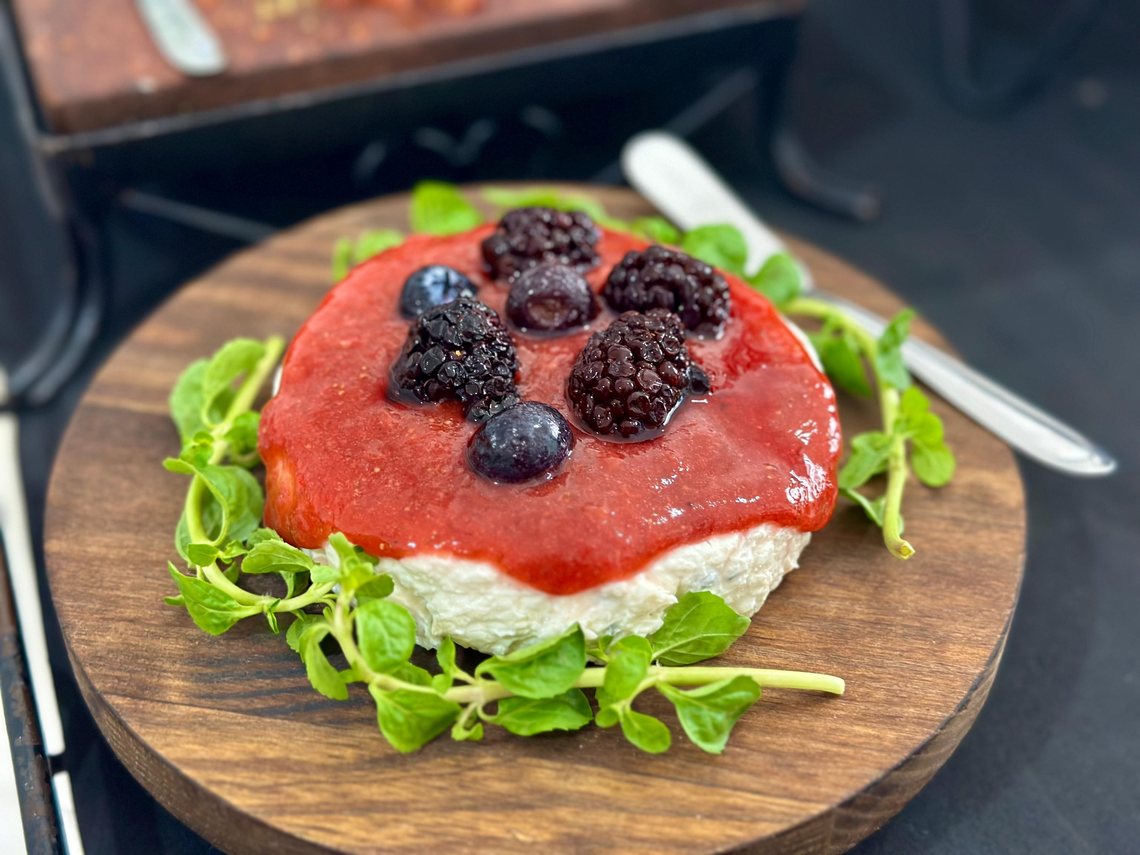 Queijo brie com geleia de frutas vermelhas e amoras frescas em tábua de madeira