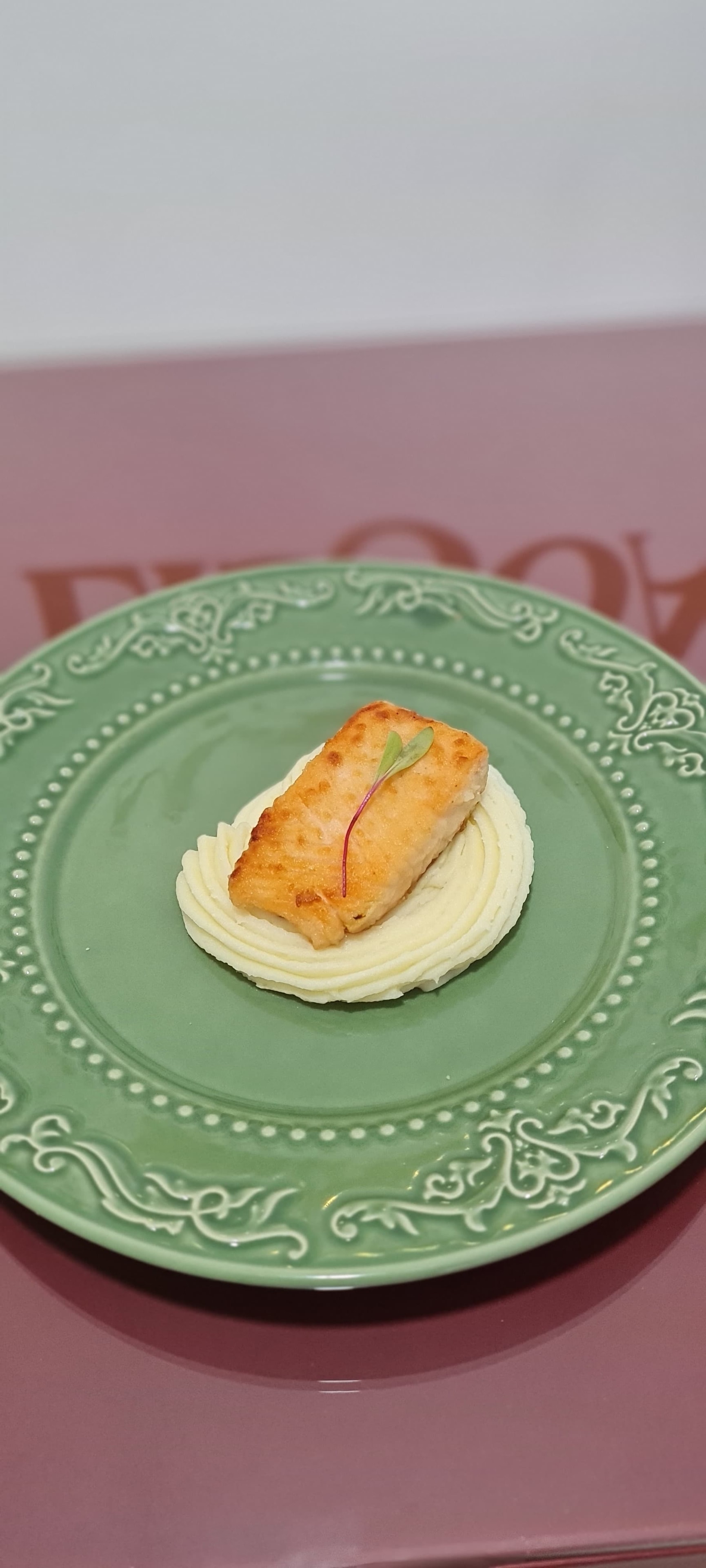 Filé grelhado com purê de batata em prato verde decorado